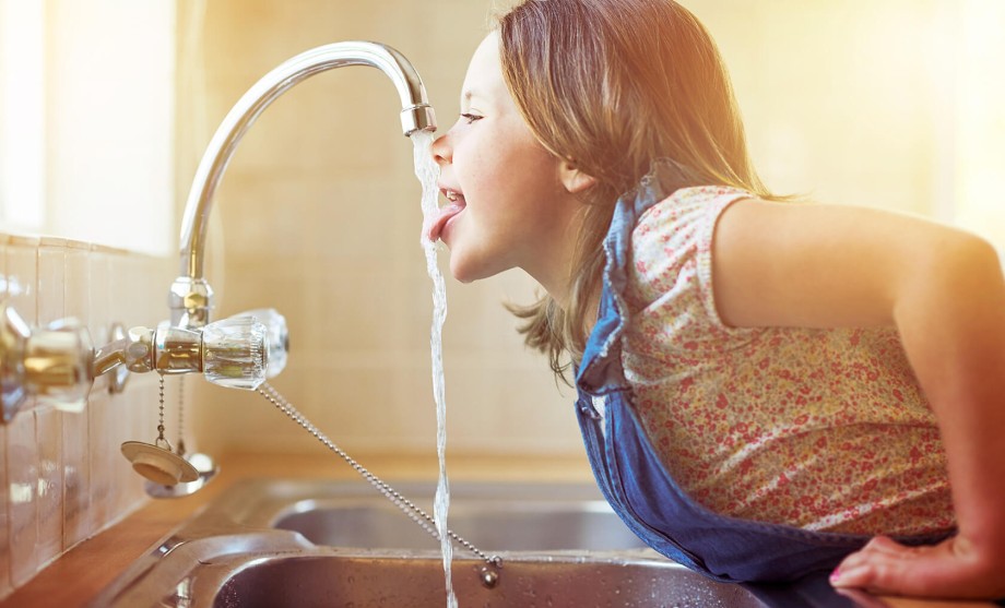 Trinkwasser: Ein Mädchen trinkt vom Wasserhahn