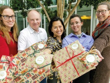 Stolz präsentieren Mitarbeitende der Stadtwerke die eingepackten Geschenke vom Weihnachtswerk