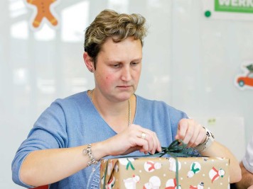 Eine Mitarbeiterin der Stadtwerke Düsseldorf packt ein Geschenk ein
