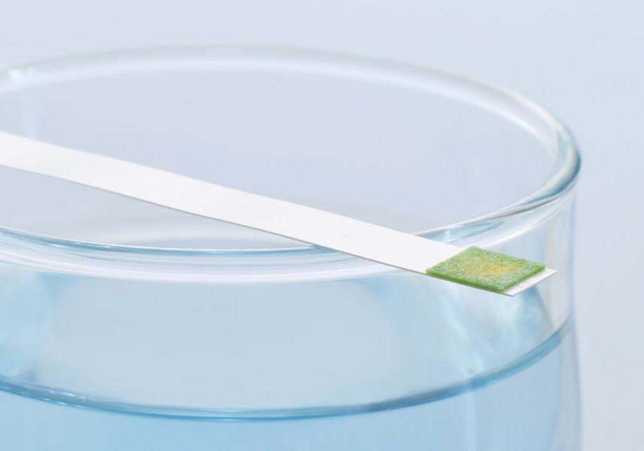 Wasserhärte: ein Wasserglas mit einem Stäbchen zur Messung der Wasserhärte