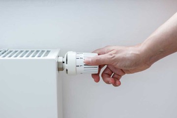 Thermografie am Haus: Hand bedient Temperaturregler an einer Heizung. © Amparo García / EyeEm via Getty Images 
