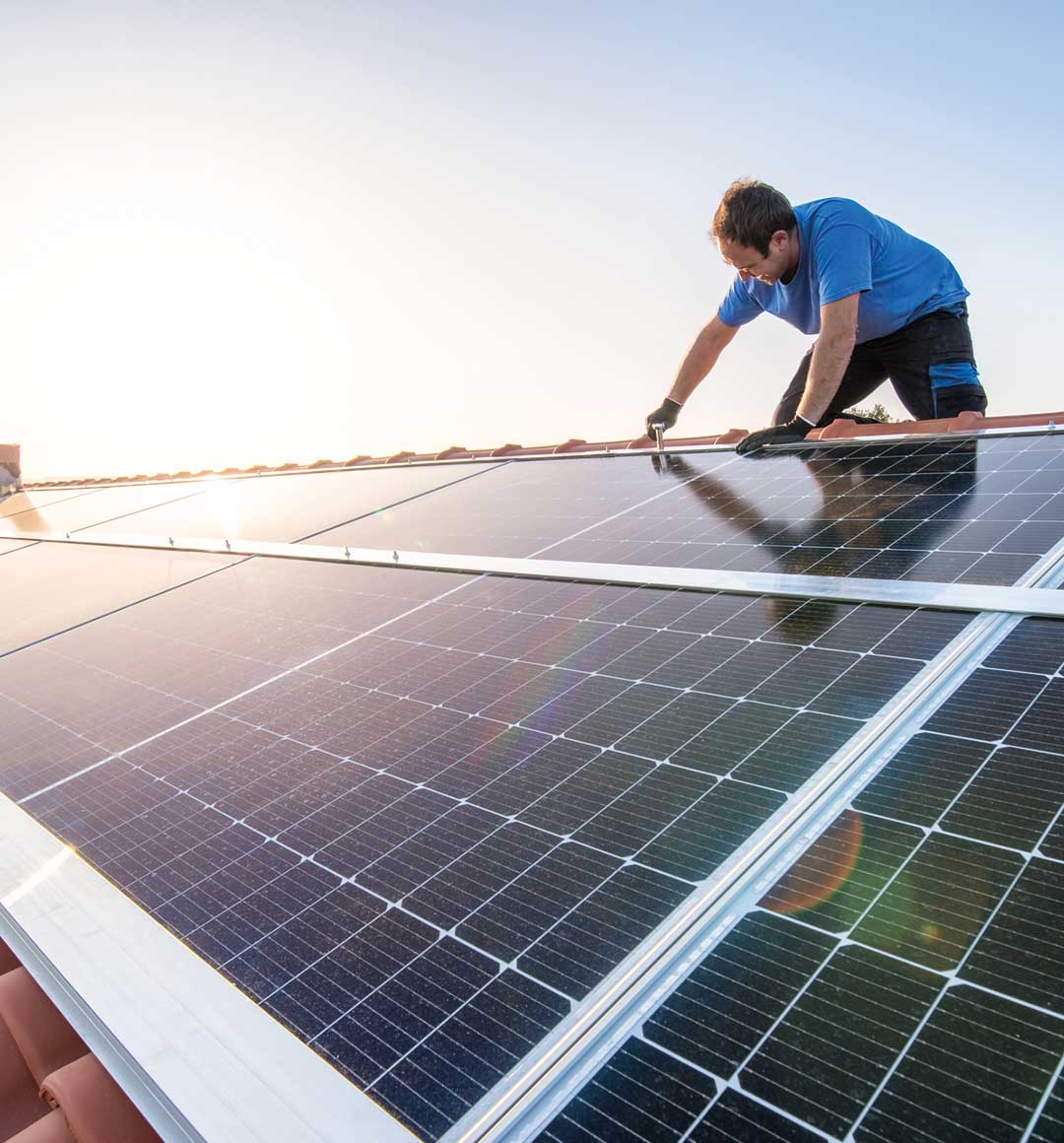Photovoltaik-Thermografie: Ein Handwerker installiert Sonnenkollektoren auf dem Dach eines Hauses. © Eloi_Omella / E+ via Getty Images