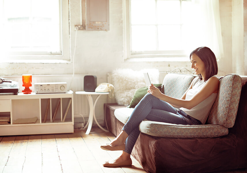 Fördermöglichkeiten: eine Frau sitzt auf der Couch mit einem Tablet