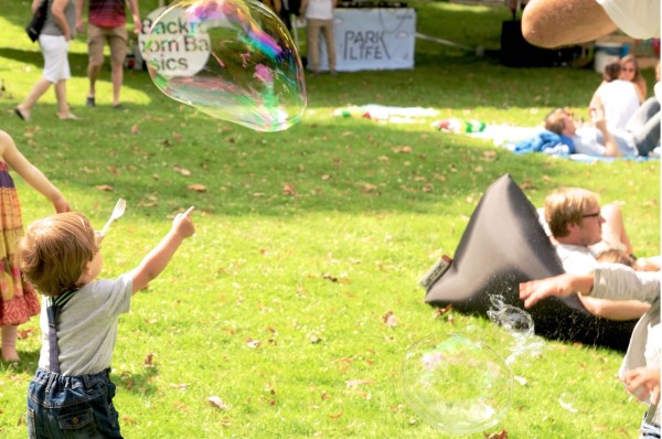 Kind zeigt auf eine große Seifenblase.