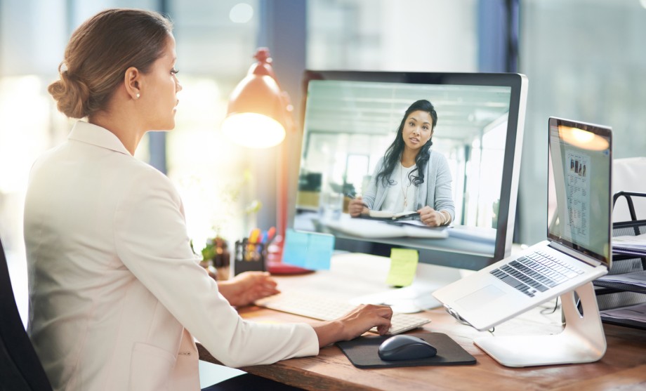 Digital Leadership: Eine Frau kommuniziert mit ihrer Arbeitskollegin via Videocall. 