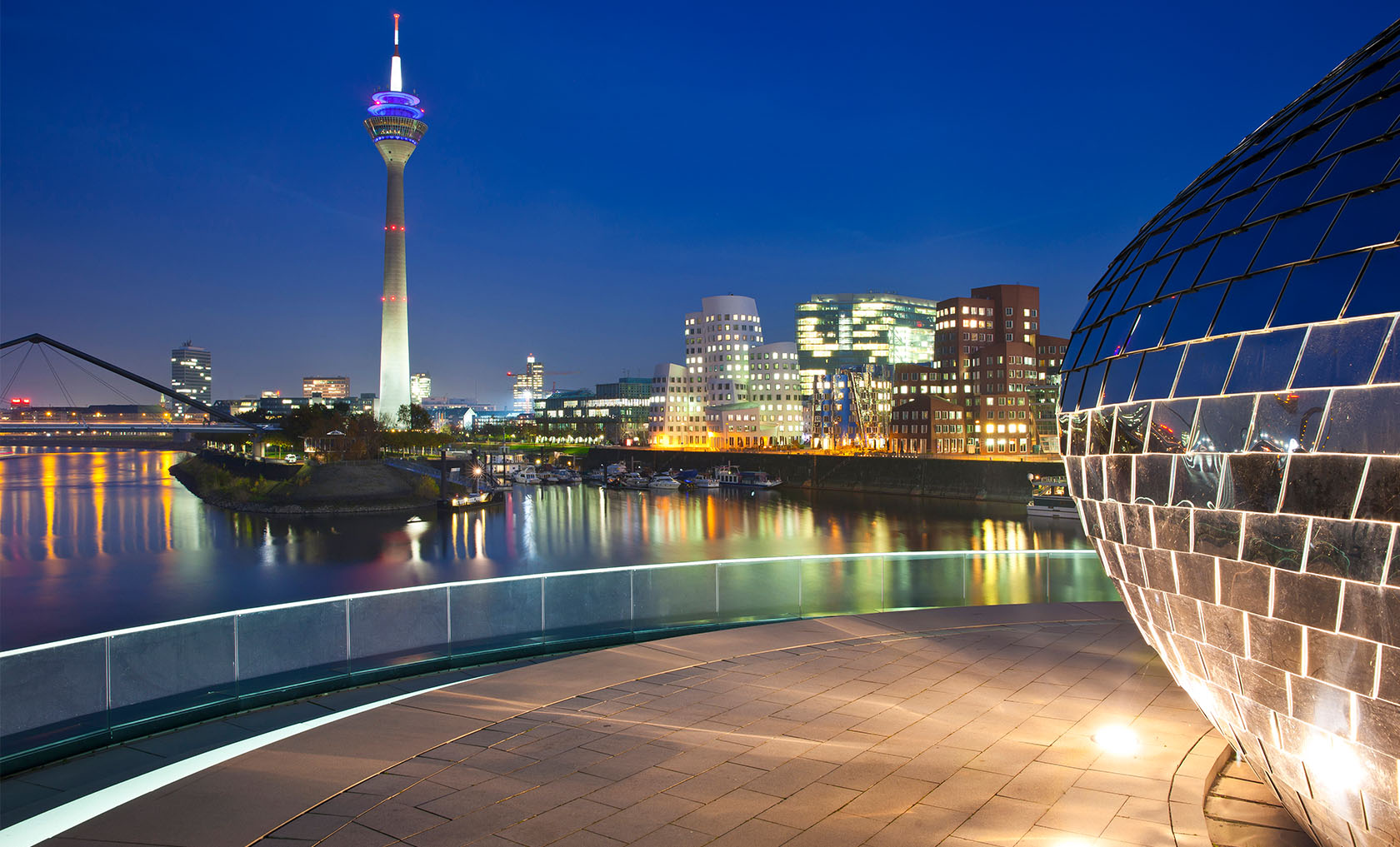 Der erleuchtete Düsseldorfer Medienhafen bei Nacht.