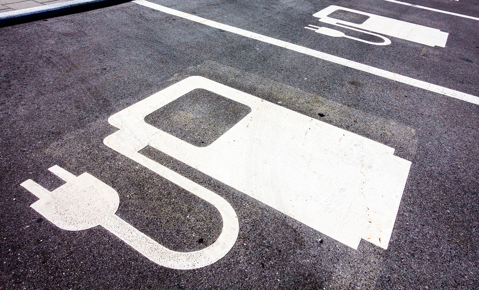 Ein Symbol einer Elektrotankstelle auf Asphalt