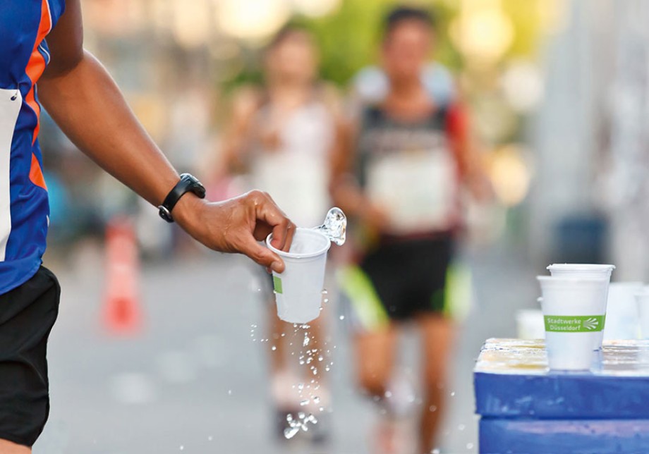 Engagement: Ein Läufer hält ein Plastikbecher mit dem Stadtwerke Logo