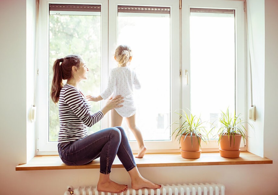 Förderungen: Eine Frau sitzt mit Ihrer Tochter auf dem Fensterbrett