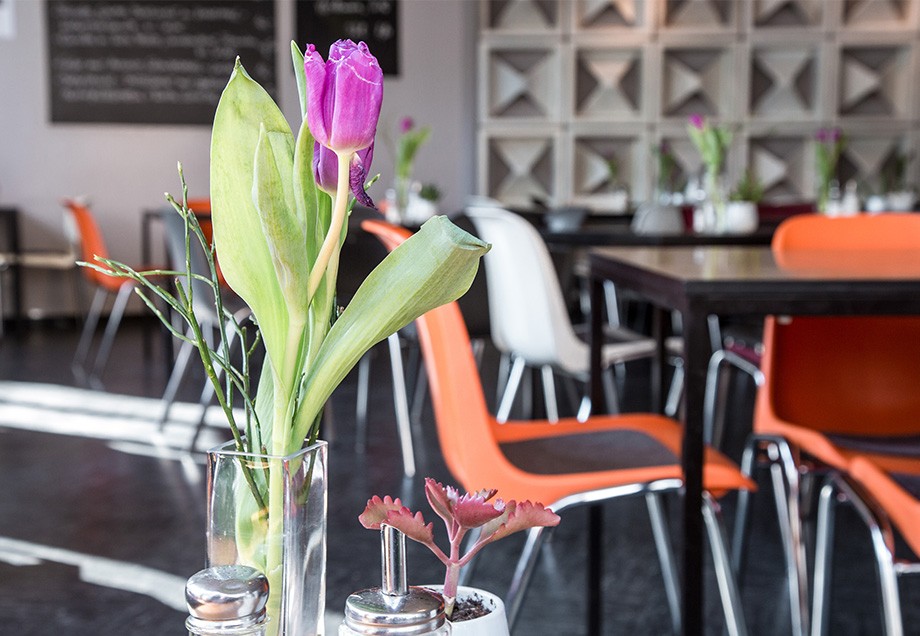 Das Kwadrat bietet neben leckeren Mittagsangeboten ein schickes Interior: Blumendeko, Tische und Stühle im Restaurant Kwadrat