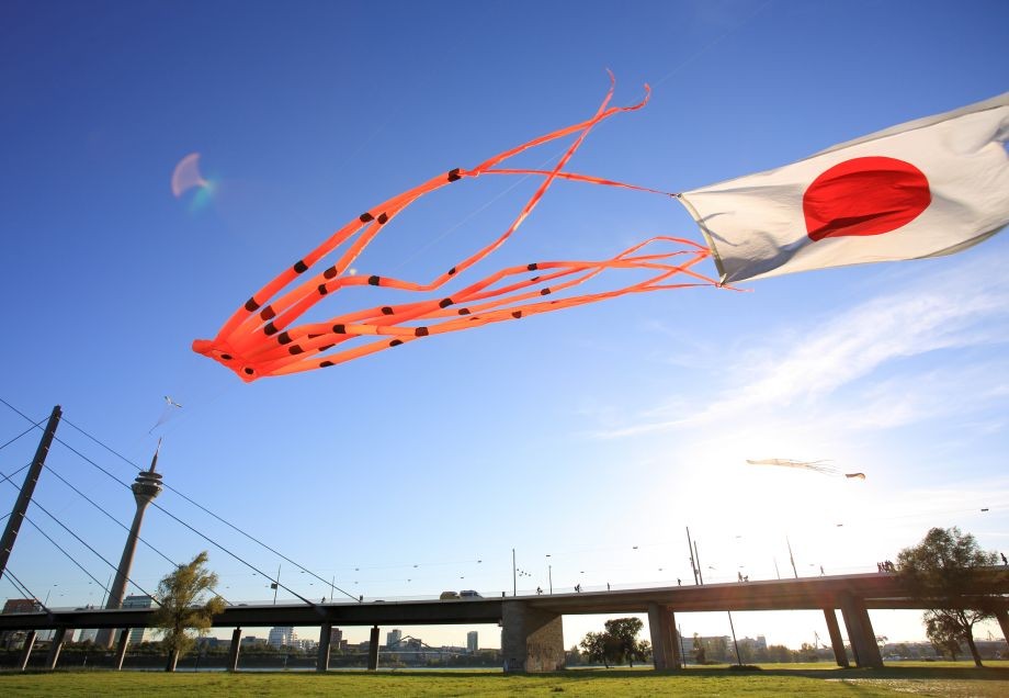 Freizeitaktivitäten: Drachen mit Japanflagge fliegt über Rheinwiese in Düsseldorf.