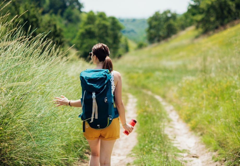 Sanfter Tourismus: Junge Frau genießt Wanderung durch Bergpfade. 