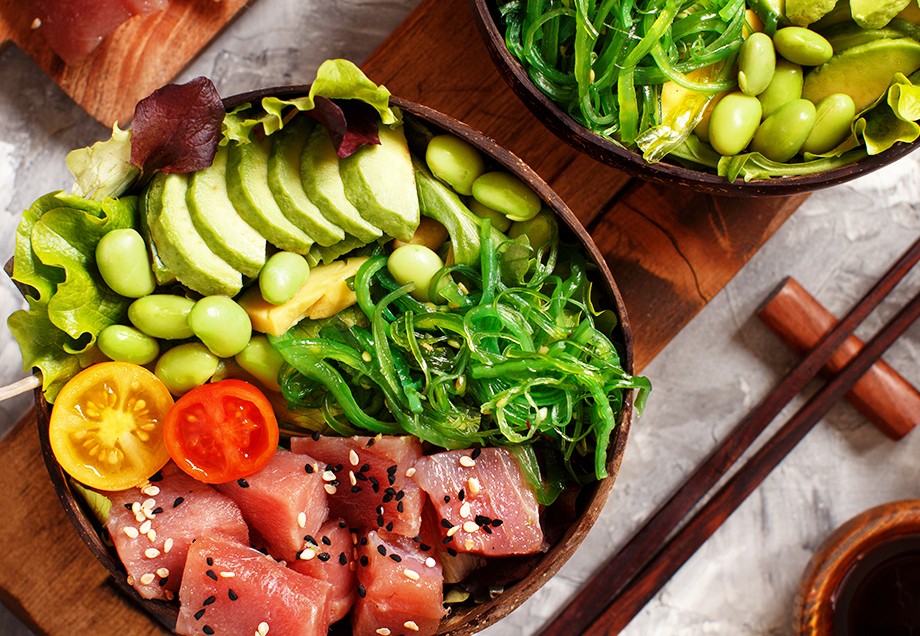 Eine Tuna Poke Bowl mit Salat und Avocado, angerichtet in einer Schale. 