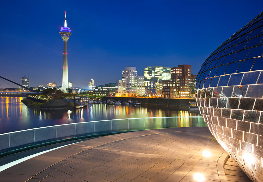Der erleuchtete Düsseldorfer Medienhafen bei Nacht.