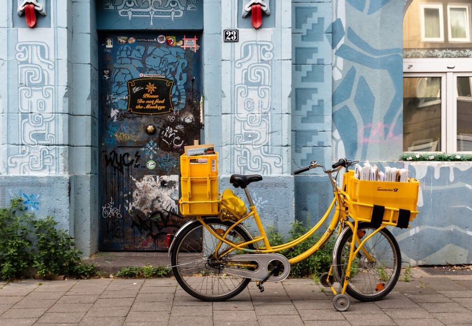 Das Fahrrad eines Postboten steht vor einer Hauswand auf der Kiefernstraße in Düsseldorf.