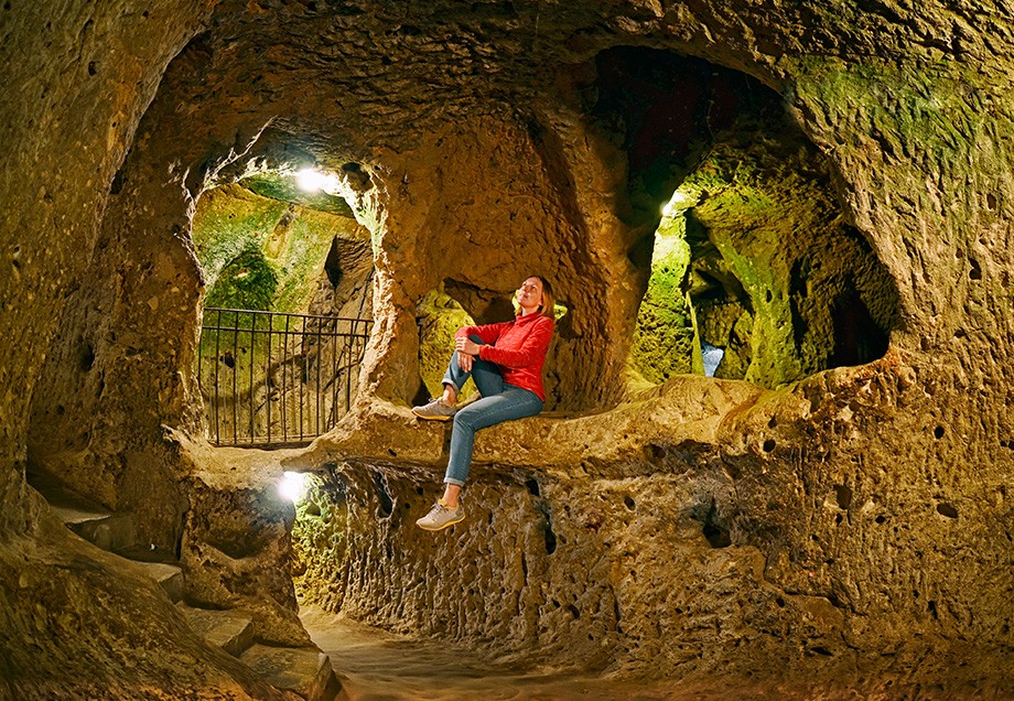 Eine Frau hält in einer Höhle inne.