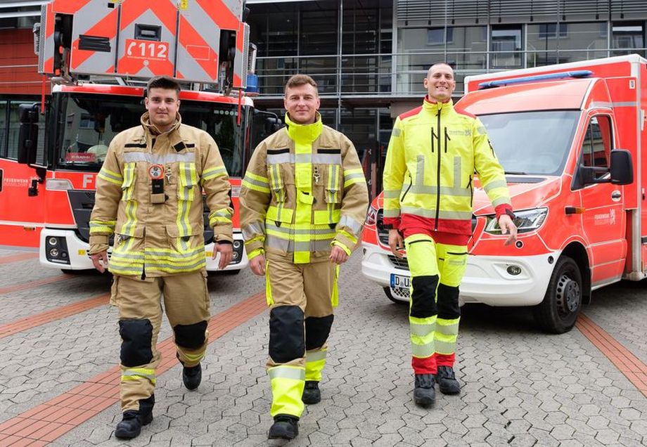Drei Feuerwehrmänner stehen vor zwei Einsatzfahrzeugen der Feuerwehr Düsseldorf. © Feuerwehr Düsseldorf 