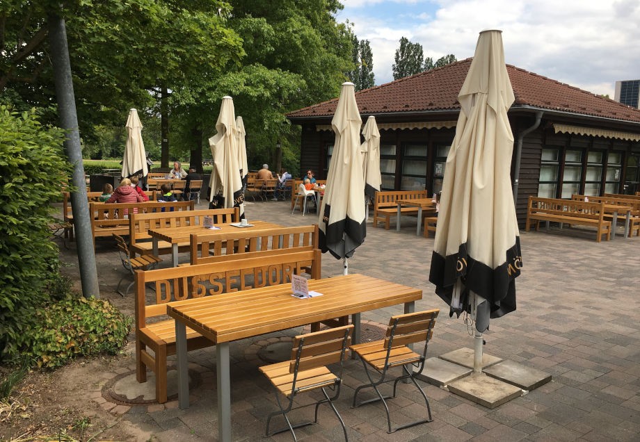 Menschen, die auf der Terrasse eines Cafés sitzen.