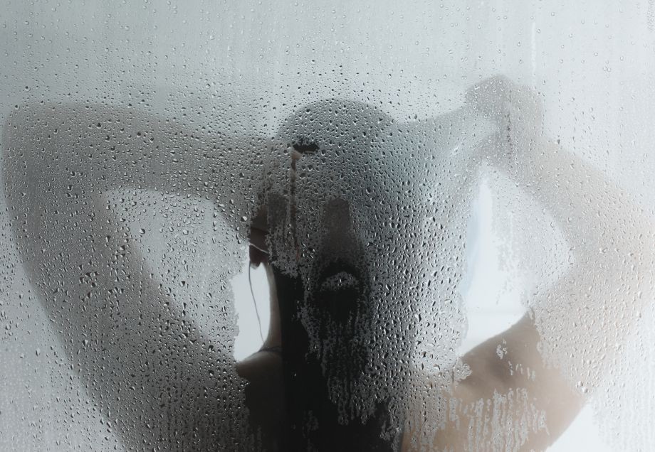 Eine Frau nimmt eine heiße Dusche. 