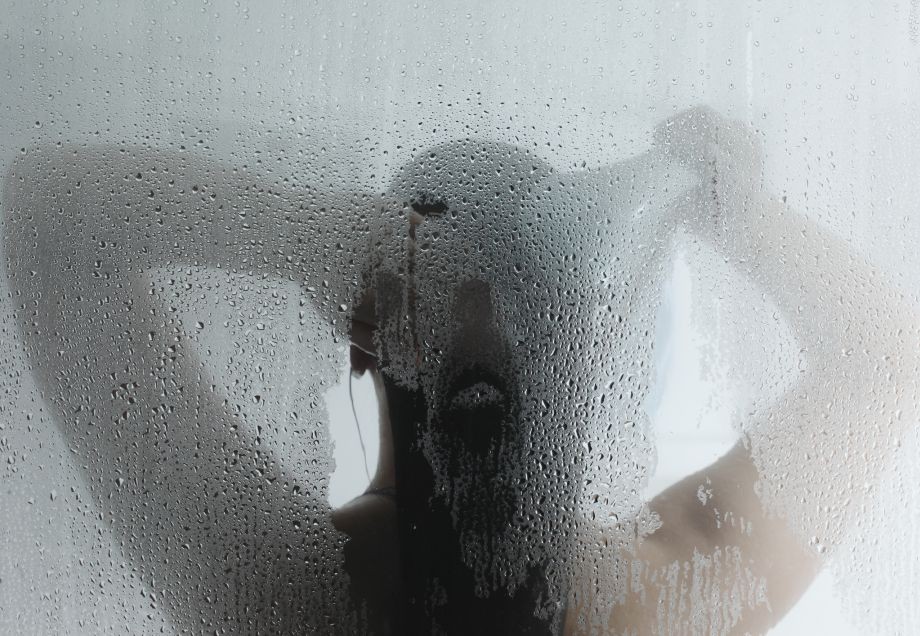 Eine Frau nimmt eine heiße Dusche.
