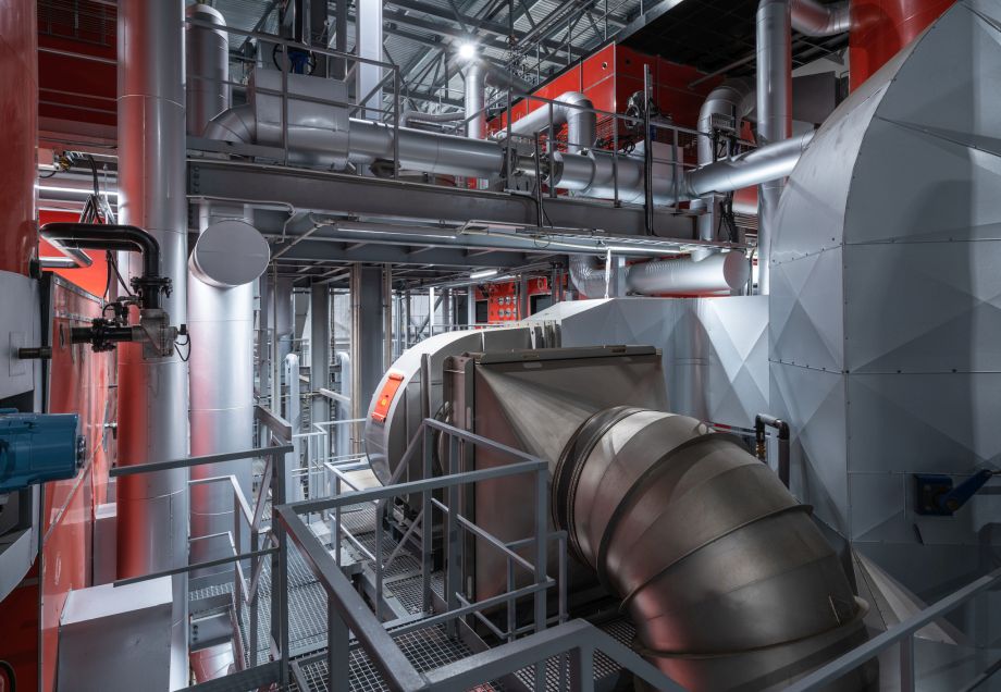 Diverse Maschinen und Leitungen in einer Fabrik. © imantsu / E+ via Getty Images