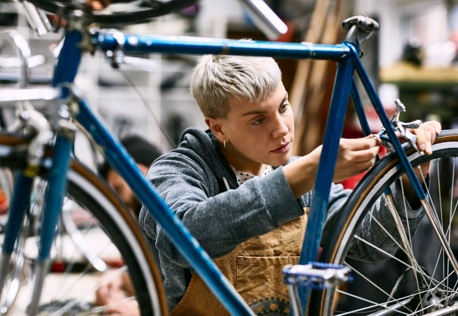 Mitarbeiterin repariert Fahrradbremse