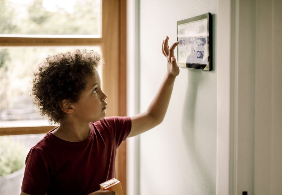 Ein Junge bedient das Dashboard zur Steuerung verschiedener Haushaltsgeräte. © Maskot via Getty Images