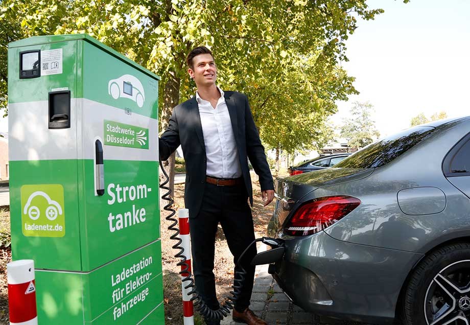 Mobilität der Zukunft: Ein Mann lädt sein E-Auto an einer Ladestation auf.