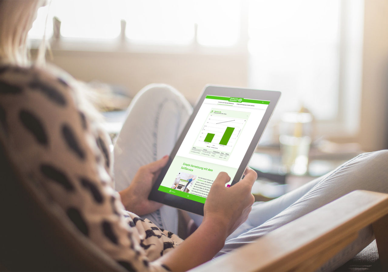 Smart Metering: Frau hält Tablet mit passender Web-Applikation in der Hand.