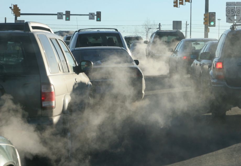 Autos mit Verbrennungsmotoren fahren auf der Straße und stoßen Feinstaub und andere Schadstoffe aus.