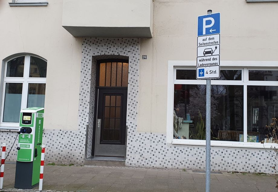 Verkehrsschilder weisen auf einen Parkplatz für E-Autos hin.