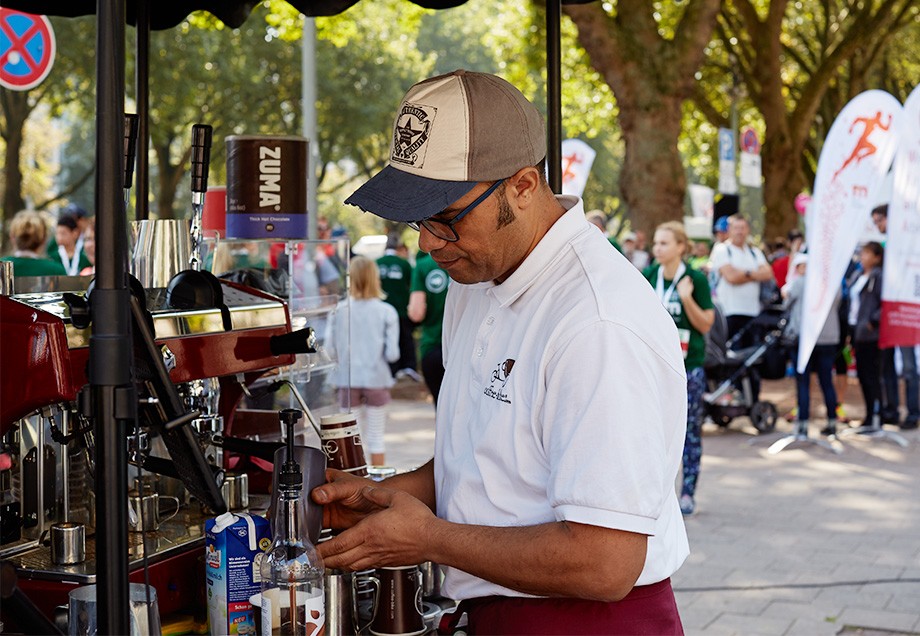Über die Anfrage, den Stadtwerke Düsseldorf Halbmarathon auf der Kö als Barista zu begleiten, hat sich Mostafa Gabbas besonders gefreut. Seine offenherzige Begeisterung für das Event legt er in jede seiner Kaffeekreationen.