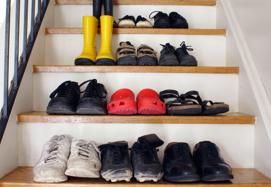 Schuhe von mehreren Personen stehen auf einer Treppe.