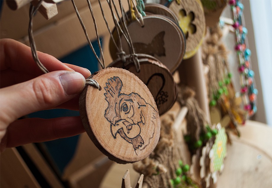 Diverse runde Holzscheiben mit Tiermotiven zum Aufhängen stehen zur Auswahl.