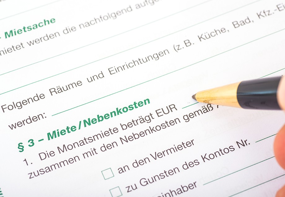 Miete und Nebenkosten werden mit einem Stift in den Mietvertrag geschrieben.