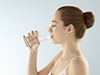 Eine Frau trinkt ihr kühles Glas Wasser. 